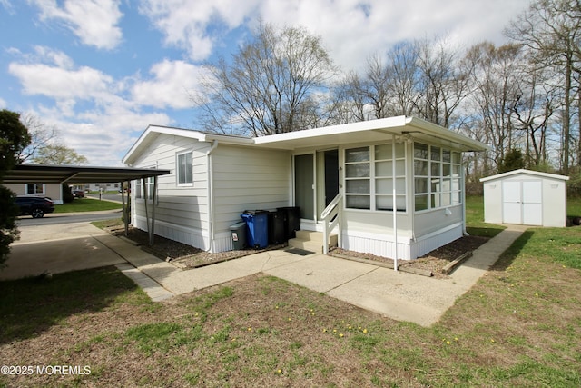 exterior space featuring an outbuilding, entry steps, a detached carport, and a shed