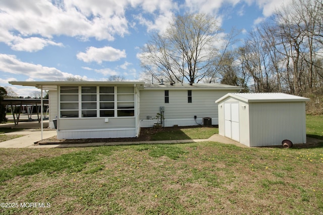 back of house featuring a shed, cooling unit, an outdoor structure, and a lawn