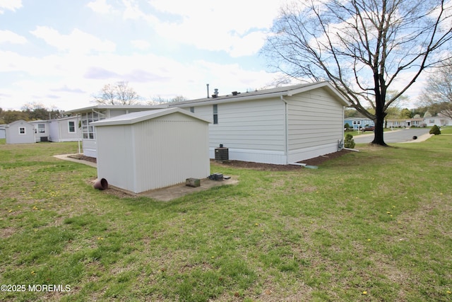 back of house featuring an outbuilding, cooling unit, and a lawn