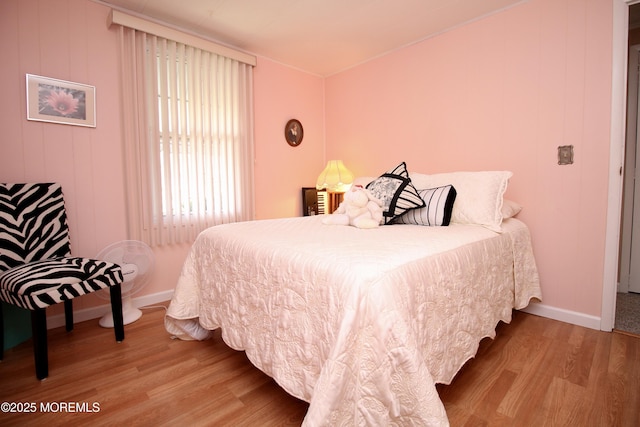 bedroom with baseboards and wood finished floors