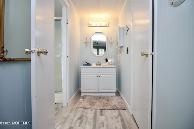 full bathroom featuring a shower stall, wood finished floors, and vanity