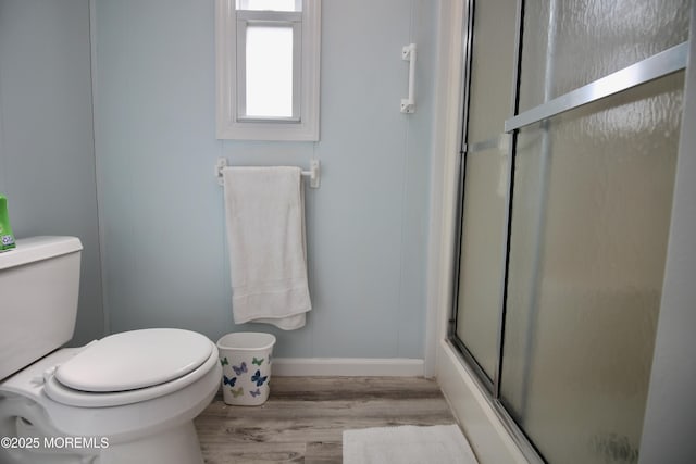 bathroom featuring baseboards, toilet, and wood finished floors