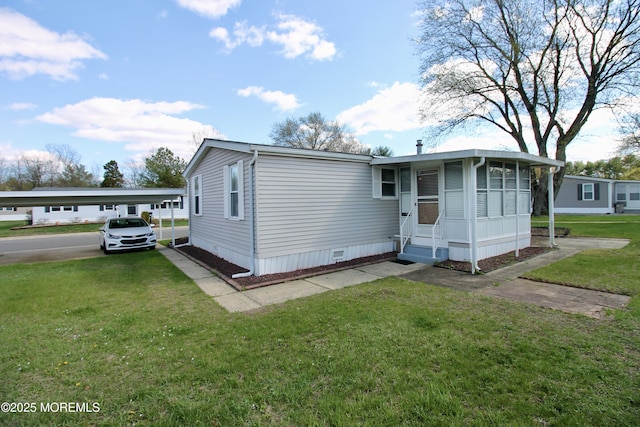 manufactured / mobile home featuring crawl space, a carport, entry steps, and a front lawn