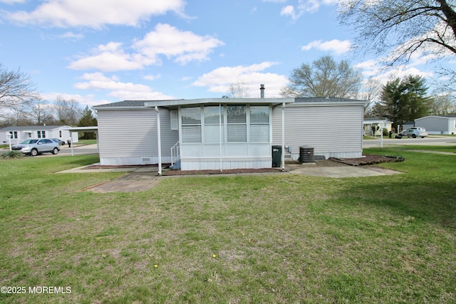 back of property featuring a sunroom and a lawn