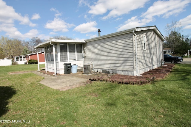 back of property with cooling unit, a sunroom, and a lawn