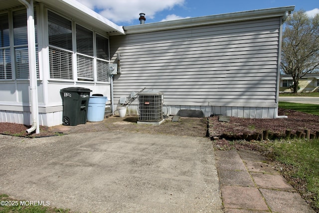 view of side of home with central AC unit and a sunroom