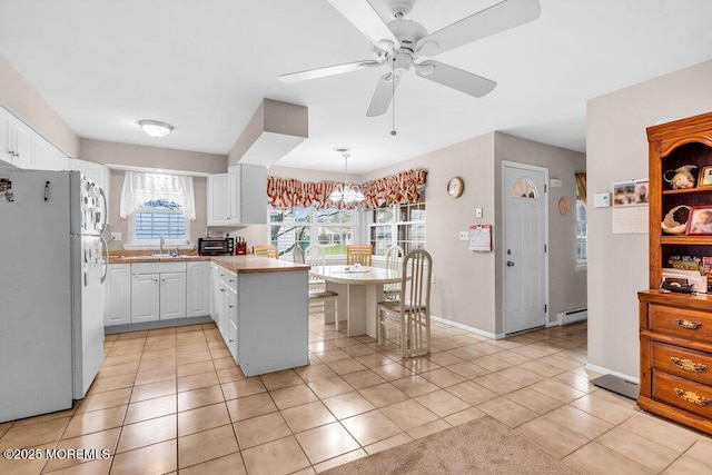 44 Buckingham Dr N, Manchester, NJ 08759 - kitchen with ceiling fan with notable chandelier, freestanding refrigerator, white cabinetry, a sink, and a baseboard radiator
