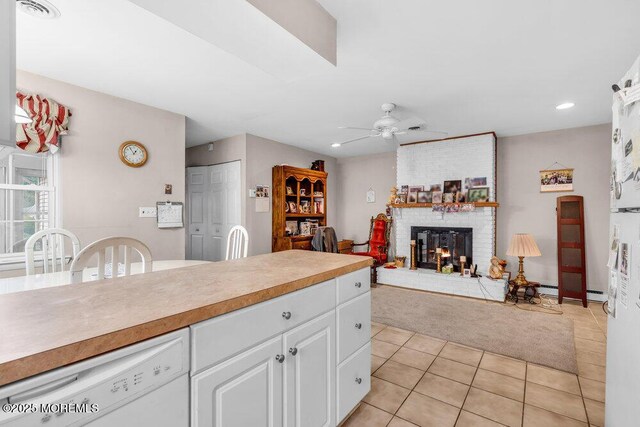 44 Buckingham Dr N, Manchester, NJ 08759 - kitchen with ceiling fan, white cabinets, light tile patterned flooring, dishwasher, and a brick fireplace