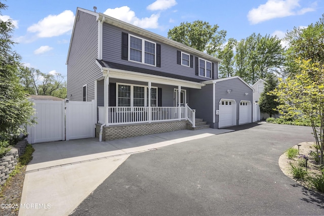628 Morningside Ave, Union Beach, NJ 07735 - view of front facade featuring a porch, a gate, driveway, and an attached garage