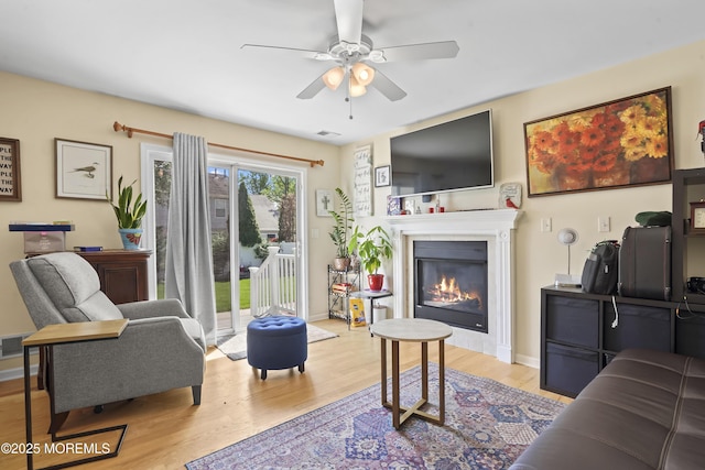 628 Morningside Ave, Union Beach, NJ 07735 - living area featuring wood finished floors, a glass covered fireplace, ceiling fan, and baseboards