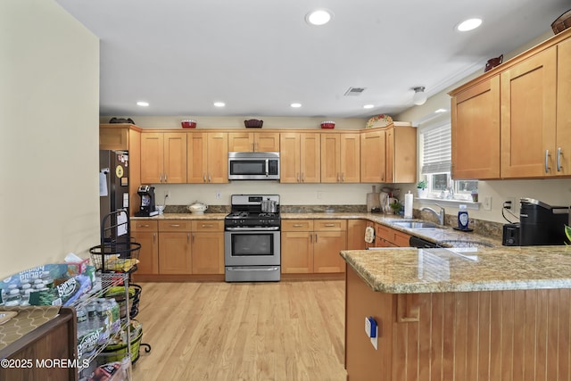 628 Morningside Ave, Union Beach, NJ 07735 - kitchen featuring appliances with stainless steel finishes, a peninsula, recessed lighting, light wood-style floors, and light stone counters