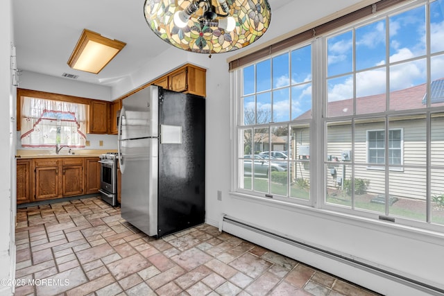 1905 Cherryvale Ct, Toms River, NJ 08755 - kitchen with stainless steel appliances, baseboard heating, brown cabinets, and plenty of natural light