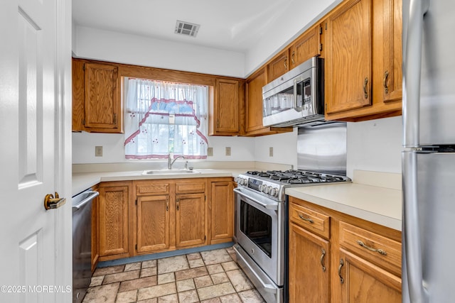 1905 Cherryvale Ct, Toms River, NJ 08755 - kitchen with appliances with stainless steel finishes, light countertops, brown cabinets, and stone finish flooring