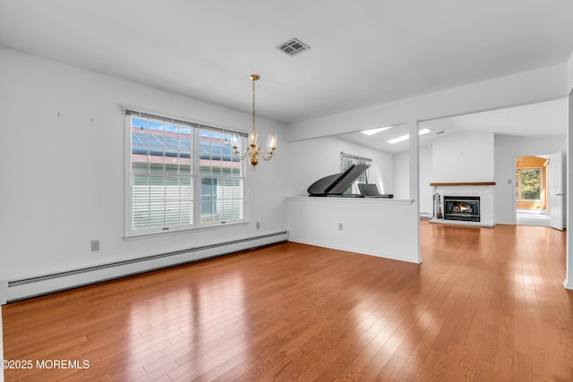 1905 Cherryvale Ct, Toms River, NJ 08755 - unfurnished living room with a baseboard heating unit, a chandelier, hardwood / wood-style floors, healthy amount of natural light, and vaulted ceiling