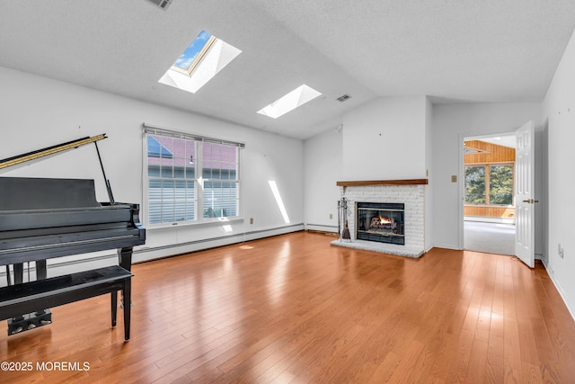 1905 Cherryvale Ct, Toms River, NJ 08755 - unfurnished living room featuring lofted ceiling, a skylight, a baseboard heating unit, a brick fireplace, and wood finished floors