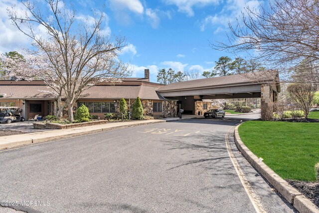 1905 Cherryvale Ct, Toms River, NJ 08755 - mid-century inspired home with asphalt driveway, a front lawn, stone siding, a chimney, and a carport