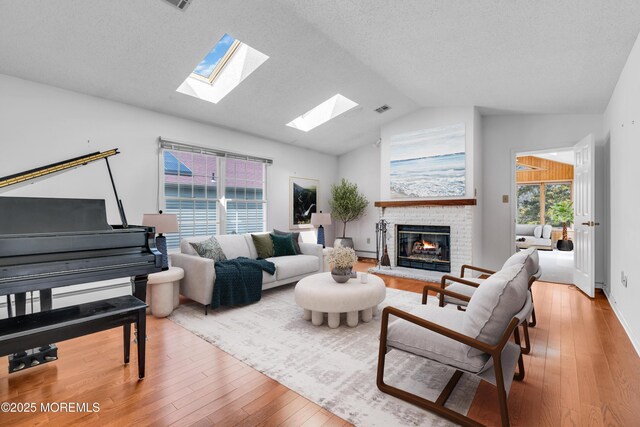 1905 Cherryvale Ct, Toms River, NJ 08755 - living area with lofted ceiling, a skylight, hardwood / wood-style flooring, a brick fireplace, and baseboard heating