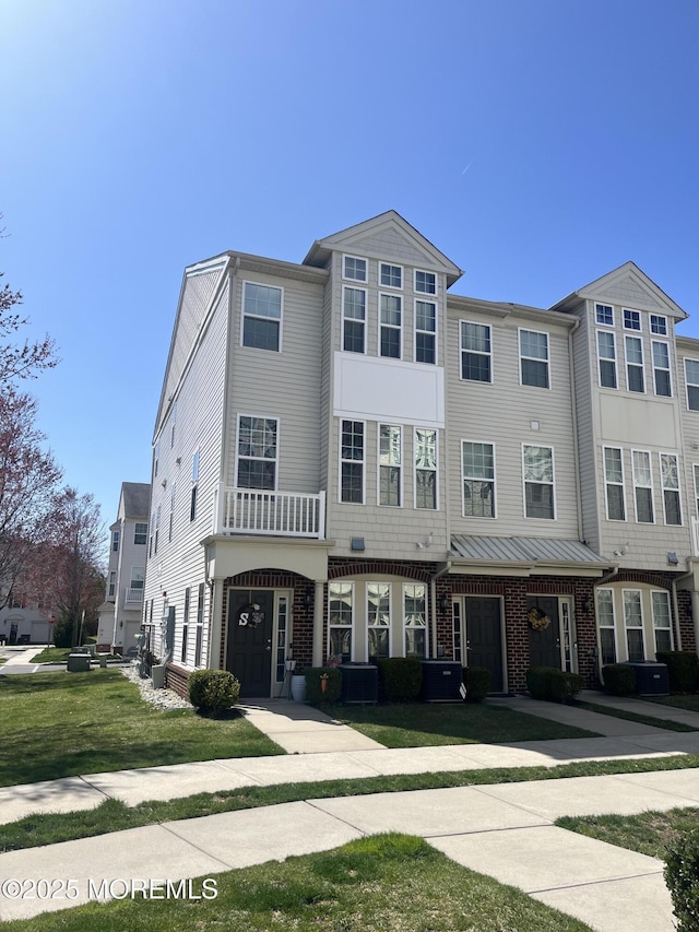 view of property with a front yard and brick siding