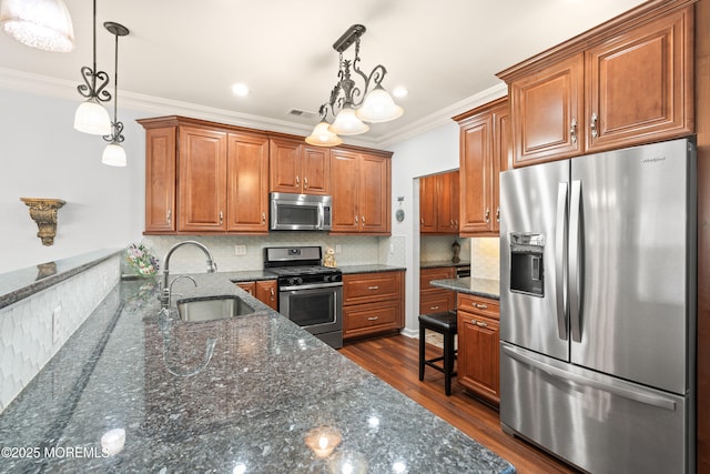 kitchen featuring brown cabinetry, appliances with stainless steel finishes, a sink, and dark wood finished floors
