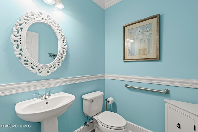 bathroom with toilet, a sink, and ornamental molding