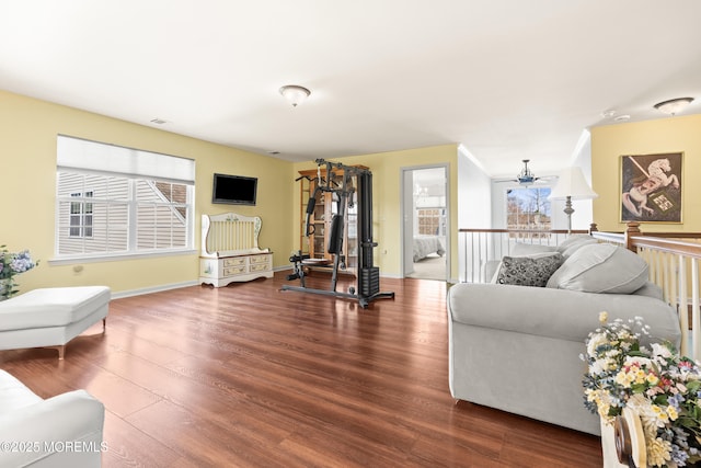 living area featuring visible vents, baseboards, and wood finished floors