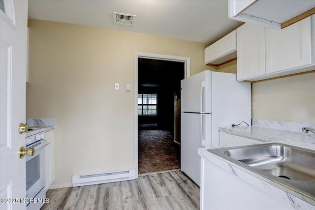 86E Dorchester Dr, Lakewood, NJ 08701 - kitchen featuring freestanding refrigerator, white cabinets, visible vents, a baseboard heating unit, and a sink
