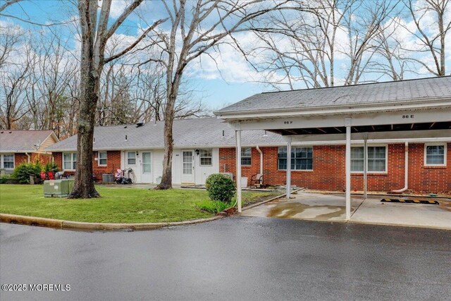 86E Dorchester Dr, Lakewood, NJ 08701 - view of front facade featuring brick siding, a front lawn, and a carport