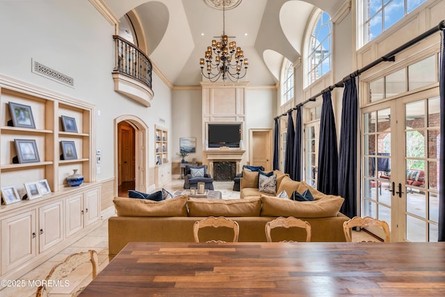 living area with french doors, an inviting chandelier, built in shelves, and a healthy amount of sunlight
