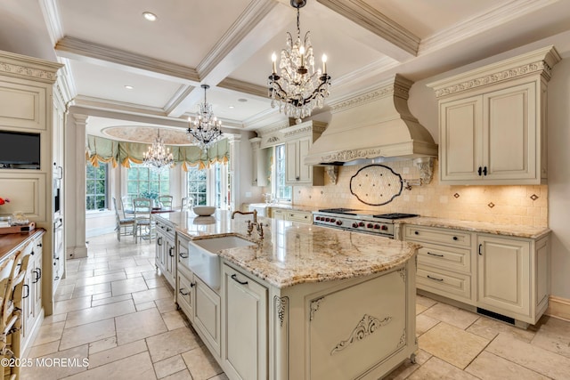kitchen with a chandelier, premium range hood, cream cabinets, and stove