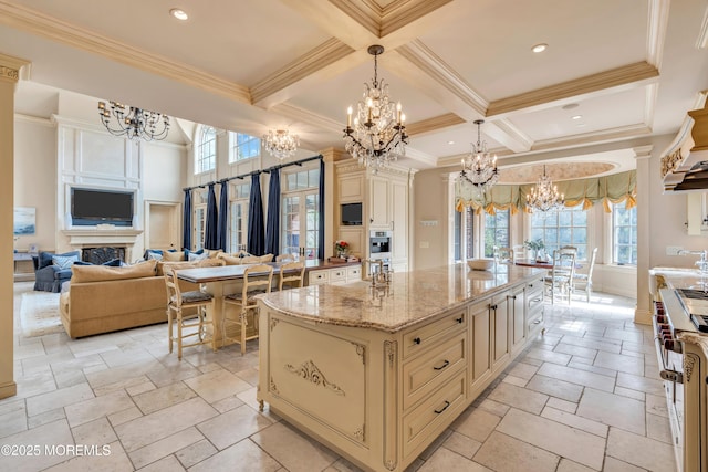 kitchen featuring an inviting chandelier, beam ceiling, and cream cabinetry