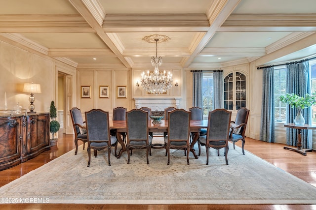 dining area featuring a decorative wall, ornamental molding, coffered ceiling, a notable chandelier, and beam ceiling
