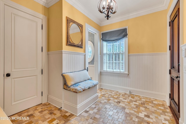 unfurnished room with a notable chandelier, ornamental molding, and a wainscoted wall