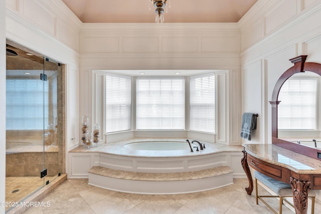 bathroom featuring a shower stall, a bath, a decorative wall, and tile patterned flooring
