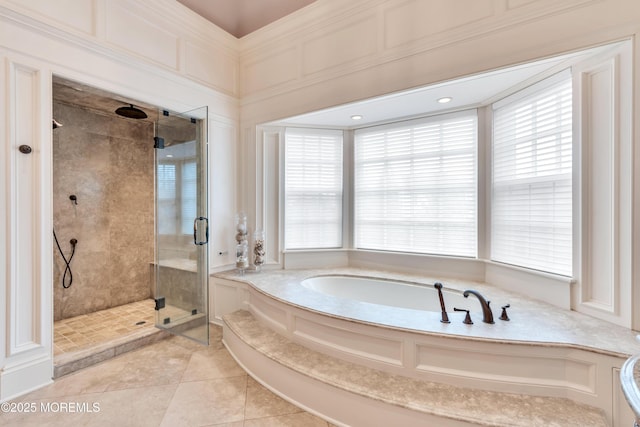 full bathroom with tile patterned flooring, a bath, plenty of natural light, and a stall shower