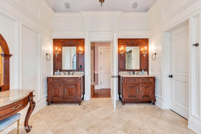 bathroom with two vanities, a sink, and ornamental molding