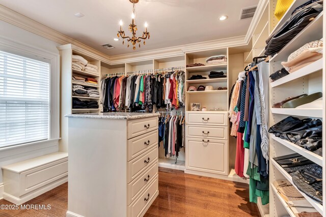 walk in closet featuring visible vents, light wood-type flooring, and an inviting chandelier