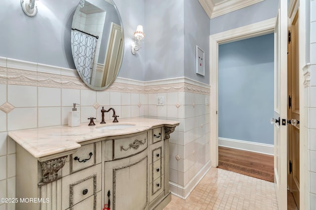 full bathroom with vanity, tile walls, ornamental molding, and wainscoting