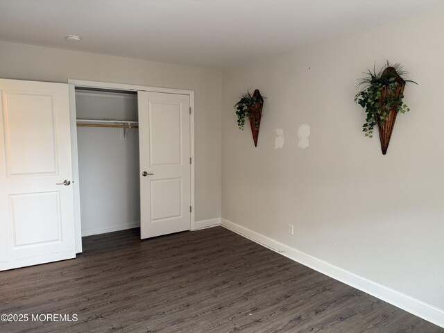 28 Riverside Ave Unit 4H, Red Bank, NJ 07701 - unfurnished bedroom with baseboards, dark wood-style floors, and a closet