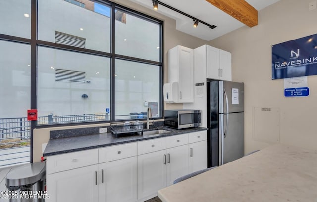28 Riverside Ave Unit 4H, Red Bank, NJ 07701 - kitchen with a sink, beamed ceiling, dark stone countertops, stainless steel appliances, and white cabinetry