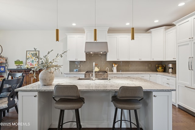 17 Spalding Dr, Holmdel, NJ 07733 - kitchen with a kitchen island with sink, tasteful backsplash, a kitchen breakfast bar, white cabinetry, and recessed lighting