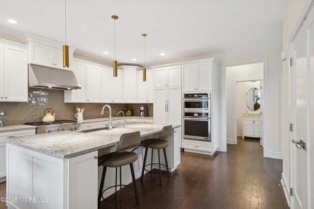 17 Spalding Dr, Holmdel, NJ 07733 - kitchen with under cabinet range hood, stainless steel appliances, dark wood-style flooring, tasteful backsplash, and recessed lighting