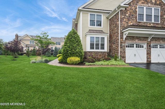 17 Spalding Dr, Holmdel, NJ 07733 - view of front facade featuring stone siding, driveway, an attached garage, a front lawn, and a standing seam roof