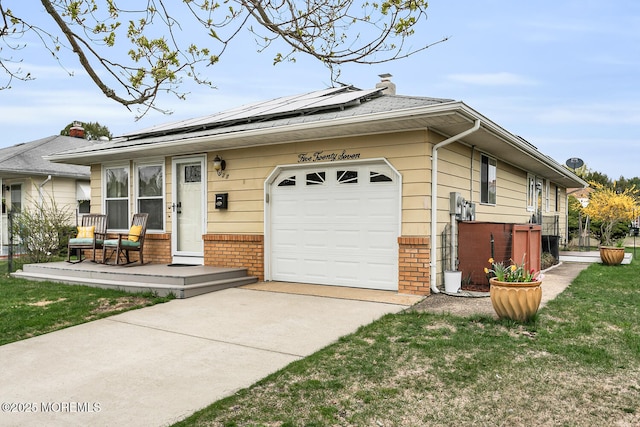view of front of house with concrete driveway, brick siding, a garage, and roof mounted solar panels