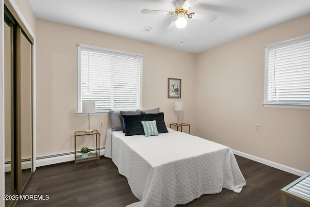 bedroom with a closet, baseboards, dark wood-style floors, a ceiling fan, and a baseboard radiator