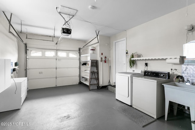 garage featuring a garage door opener, a sink, and washing machine and clothes dryer