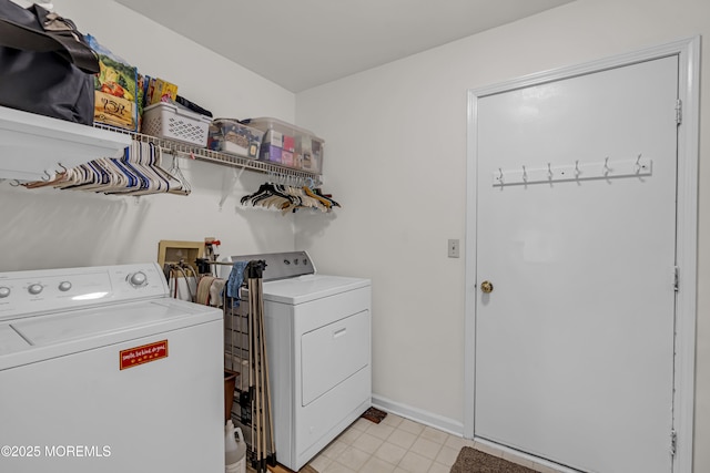 clothes washing area featuring washing machine and dryer, baseboards, and light tile patterned floors