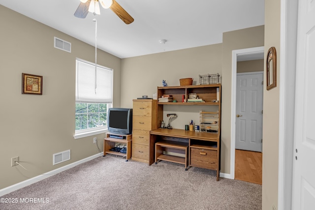 office space featuring light carpet, ceiling fan, and baseboards