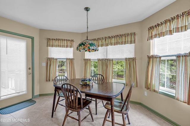 dining room featuring plenty of natural light and baseboards