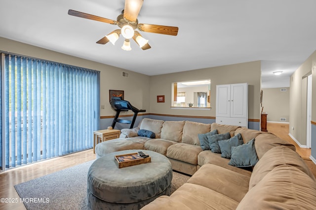 living room featuring wood finished floors, ceiling fan, and baseboards