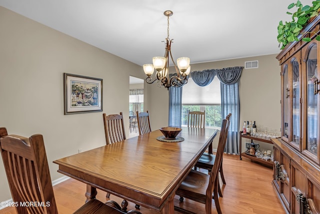 dining room with light wood-style floors, a chandelier, and radiator heating unit